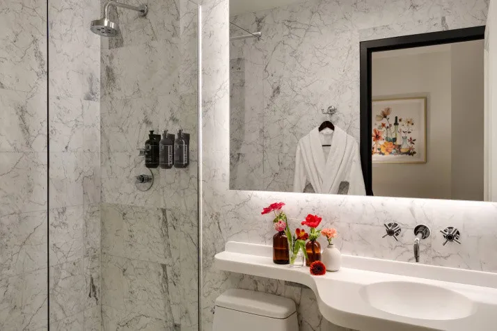 Luxury bathrooms at The Chemists' Club Hotel NYC features marble surfaces and refined fixtures in Midtown